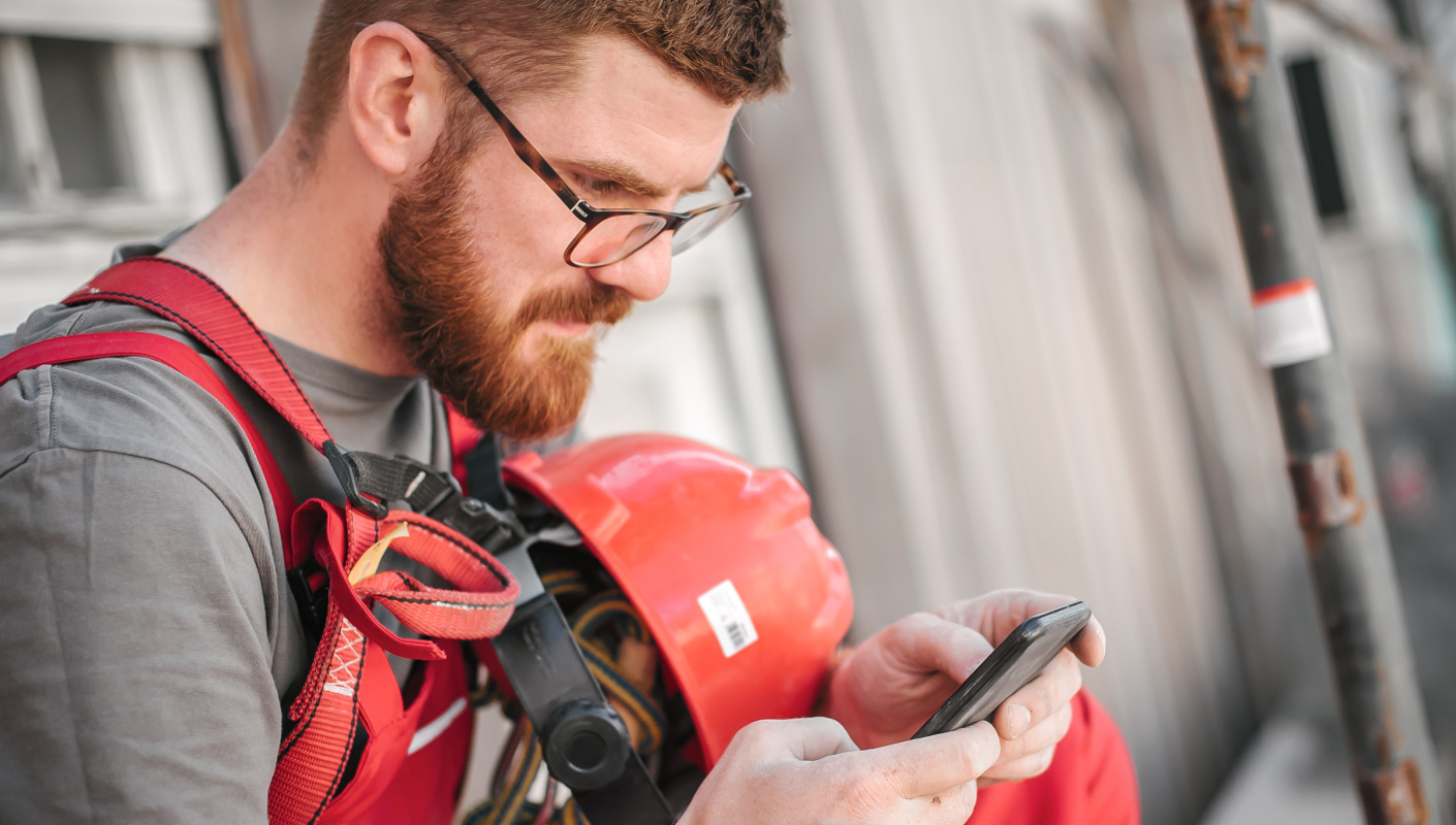 energy worker using telehealth on his phone