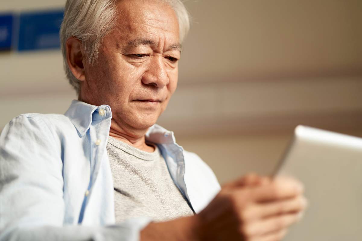 older man chatting with doctor on tablet