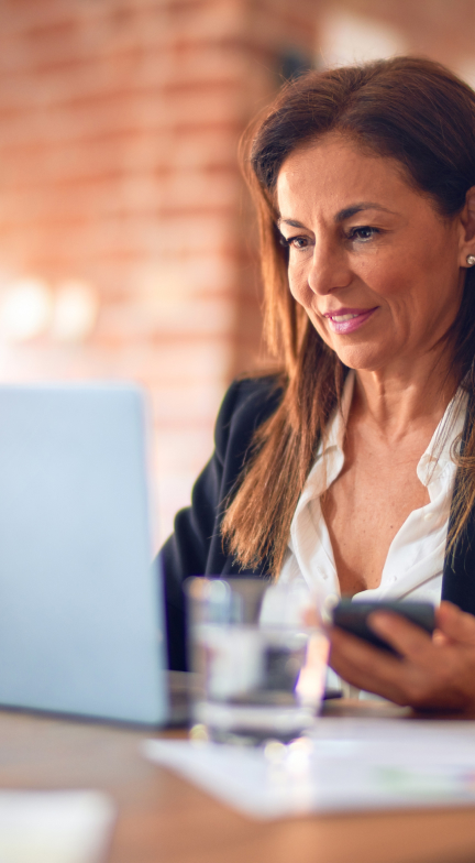 Woman on laptop with phone