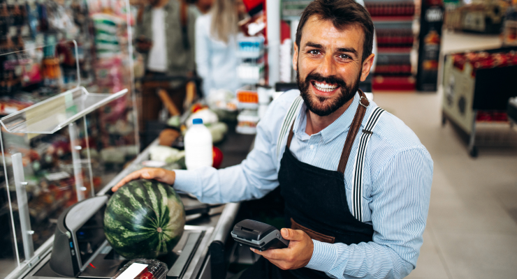 grocery worker at checkout smiling