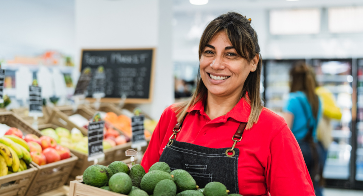 Grocery worker smiling because they love their benefits